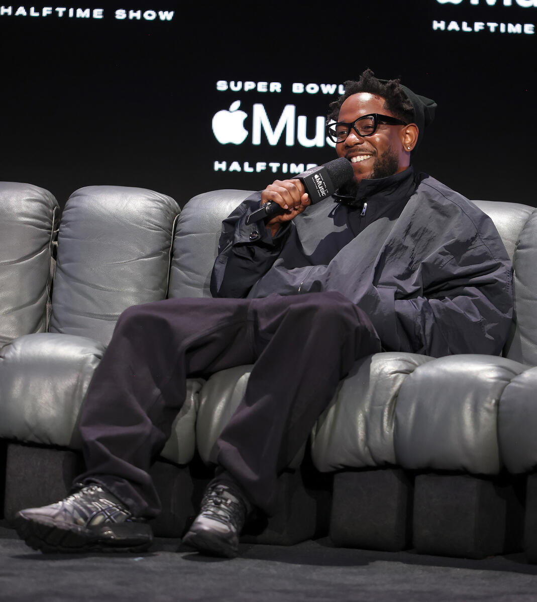 Kendrick Lamar at the Super Bowl LIX Apple Music Halftime Show press conference on Feb. 6 in New Orleans, athleisure, windbreaker, Asics