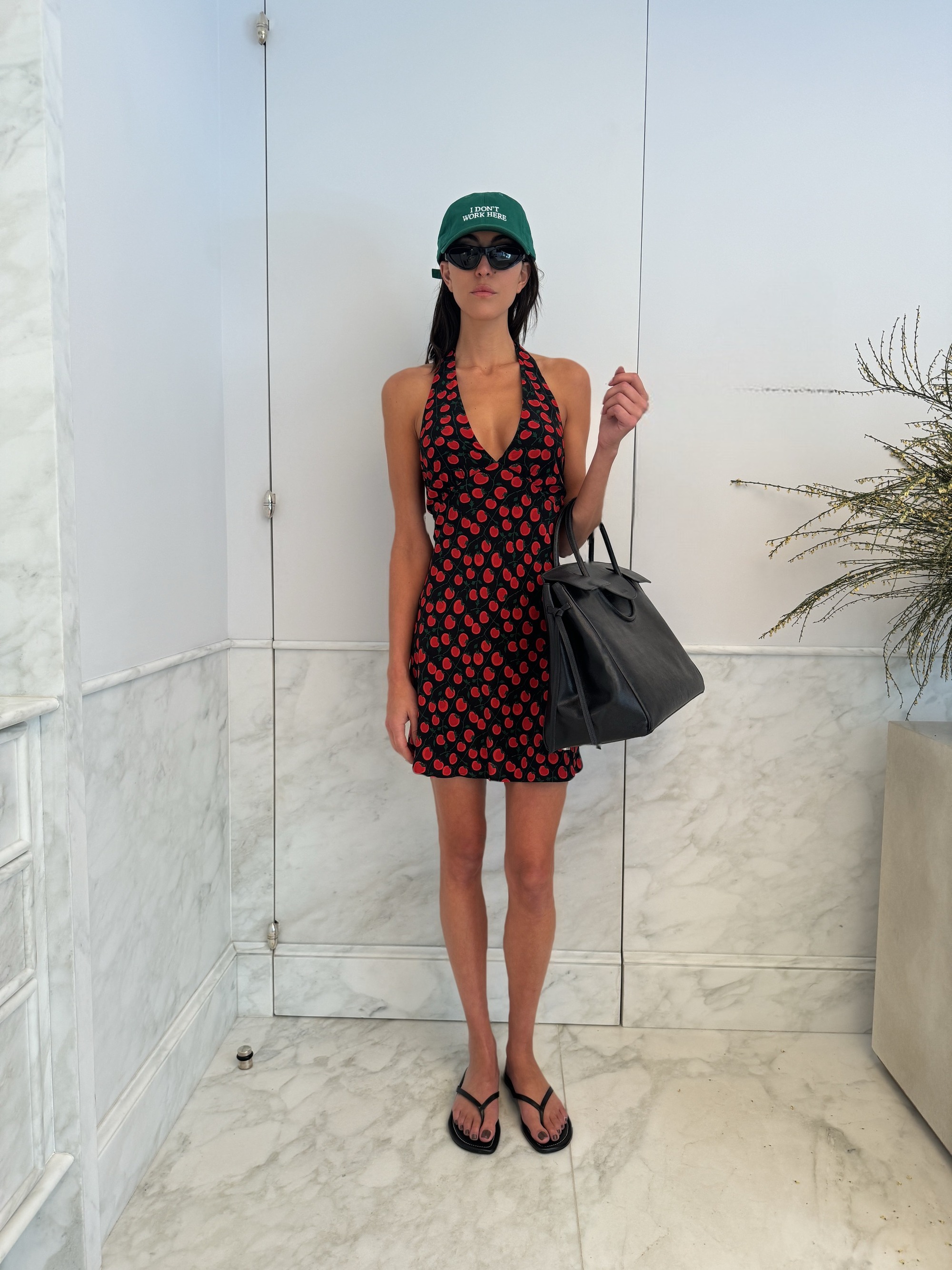 Sarah Staudinger in the Staud Lucca Mini Dress in on the vine black, Freja thong in black and Maude Carryall in black