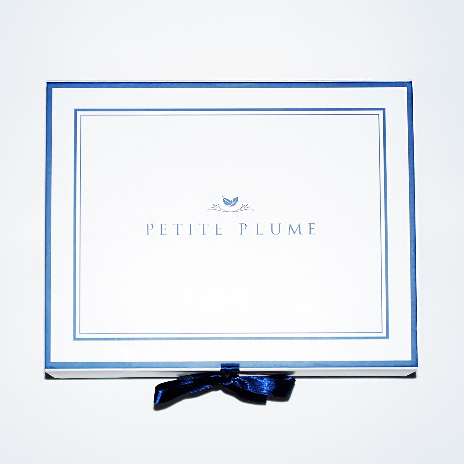 petite plume package in blue and white, with a blue bow