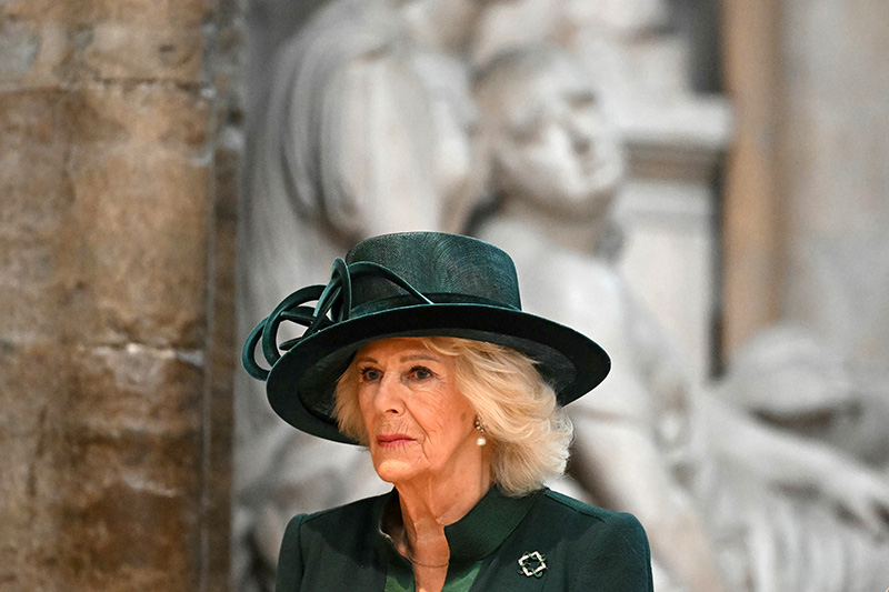 Queen Camilla wears an emerald green dress by Anna Valentine with coordinated brooch and hat at The National Harvest Festival Service at Westminster Abbey on Oct. 16, 2025 in London.