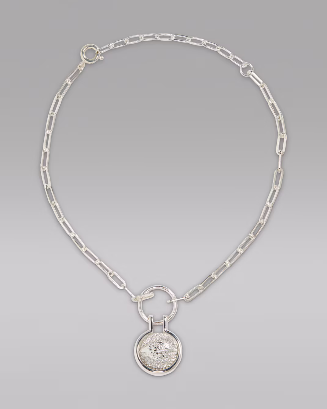 a nike x swarovski silver pendant necklace with a central, crystal-clad charm, part of the new nike x swarovski air jordan 1 shoe release