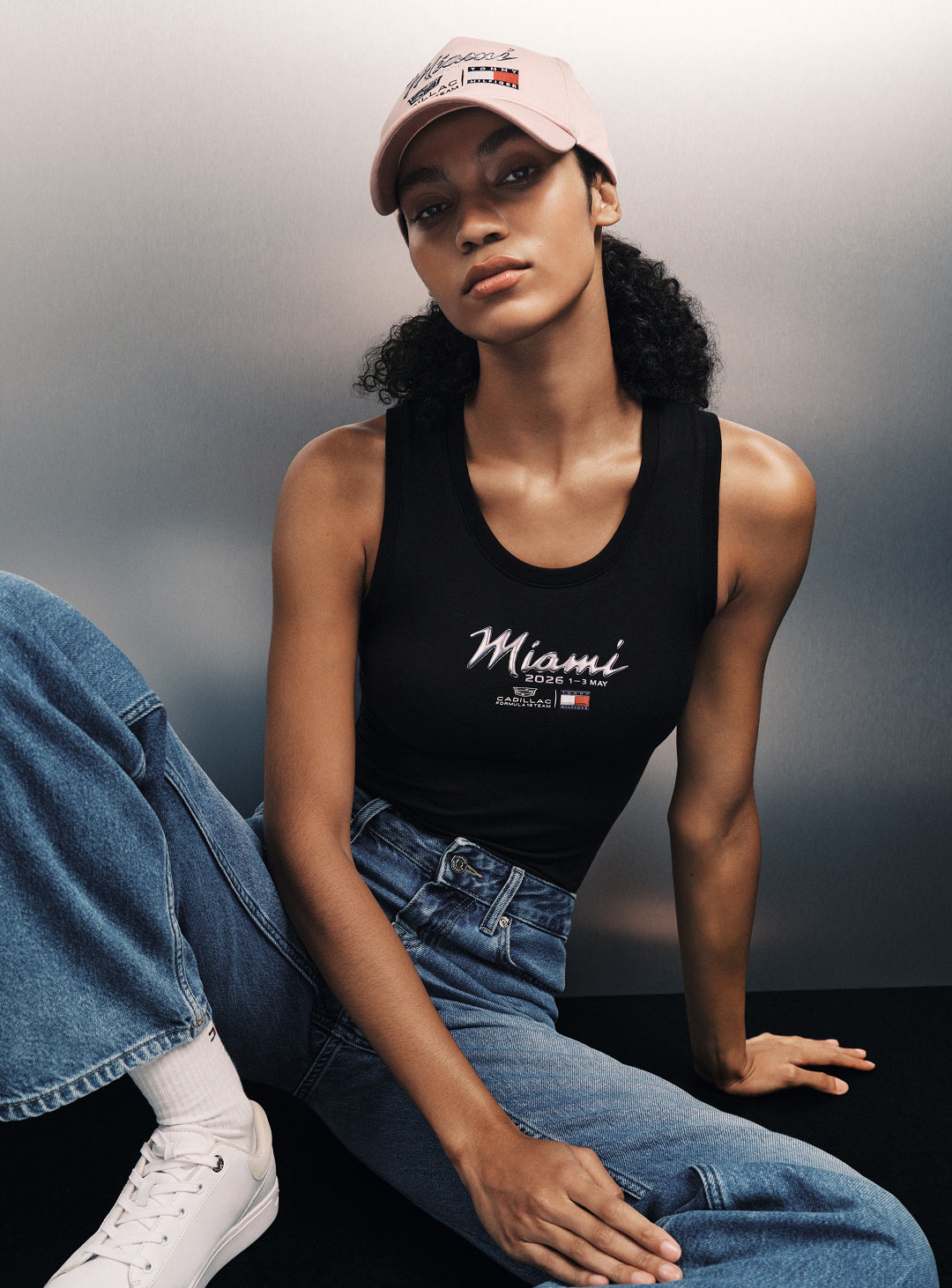 model posing in tommy hilfiger x f1 miami tank top for women; buy official f1 miami merch tommy hilfiger